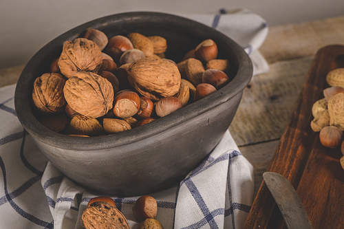 Walnuts, hazelnuts, peanuts and nuts on wooden table.