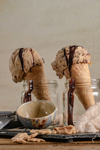 Homemade chocolate ice cream in waffle cones and pieces of dark chocolate.