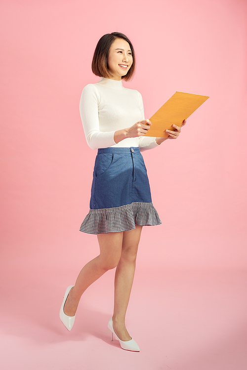 Full-length portrait of businesswoman with folder, isolated on pink. Concept of leadership and success