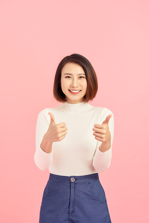 Young Asian woman show thumbs up on pink background