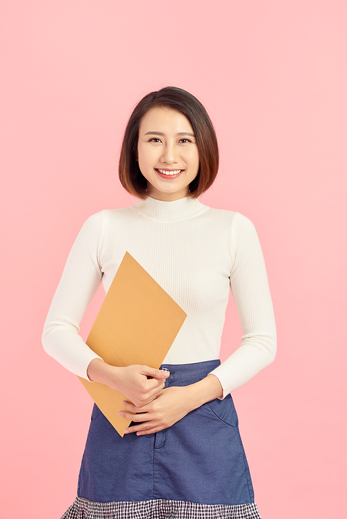 Young Asian business woman holding a file, isolated on pink background