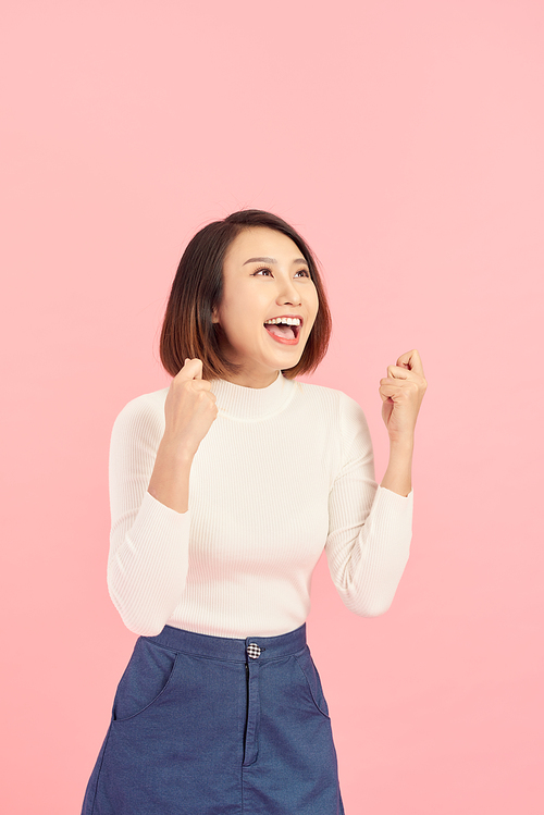 Portrait of an excited asian businesswoman  isolated over pink background