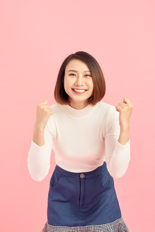 Portrait of an excited asian businesswoman  isolated over pink background