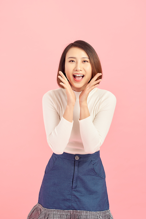 Portrait of an excited asian businesswoman  isolated over pink background