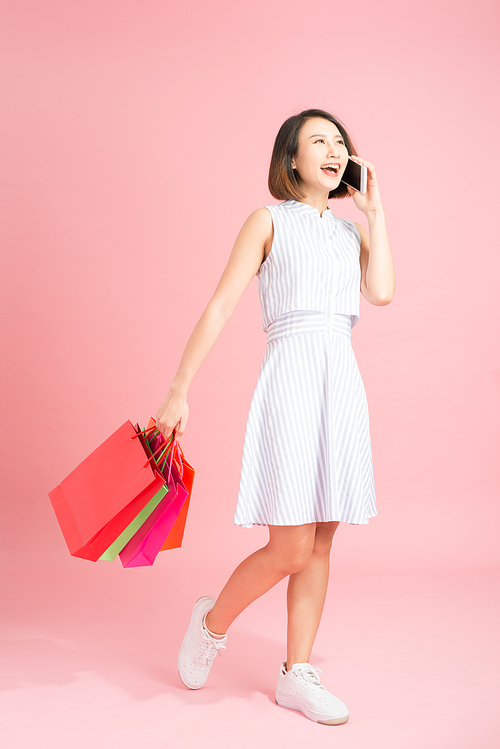 Woman carrying shopping bags and talking on mobile phone