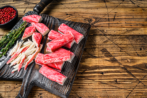 Sliced Crab sticks and meat on a wooden cutting board. wooden background. Top view. Copy space.