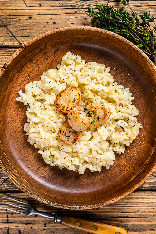 Italian  Risotto with Scallops in a pan. wooden background. Top view.