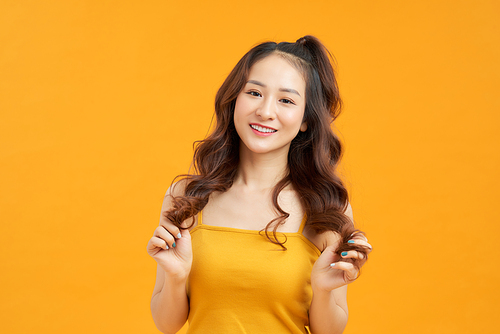 Portrait happy young asian woman feeling carefree laughing positive emotion on yellow background