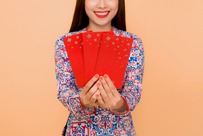 Beautiful asian woman on traditional festival costume Ao Dai holding lucky pocket money