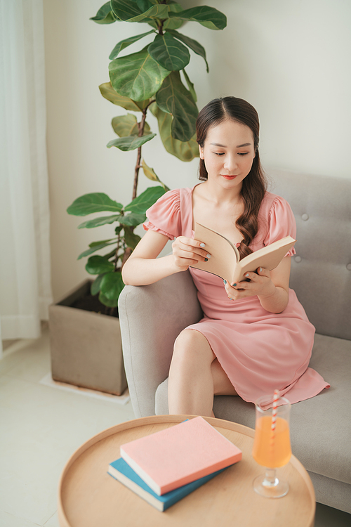 Asian woman relax resting with book sit on couch or sofa