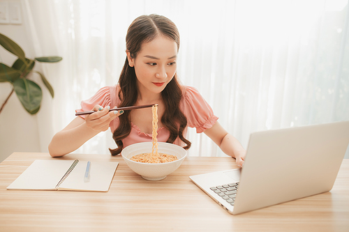 Smart business women work eat food Instant noodles Laptop computer