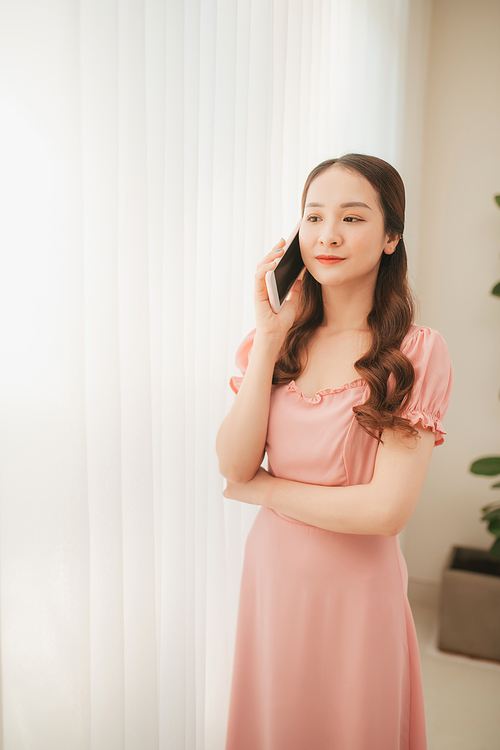 Beautiful young asian woman calling and talking with family by using mobile phone