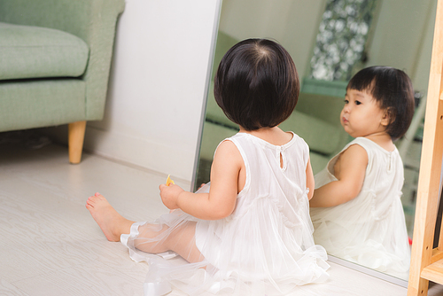 Little cute asian baby girl sitting on floors playing