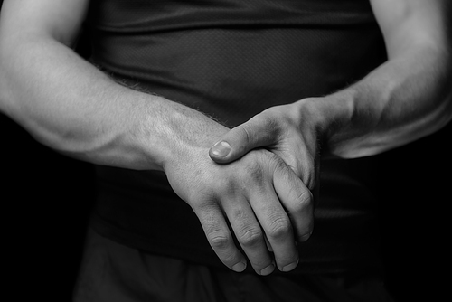 Pain in a male wrist. Man holds his hand, monochrome  image