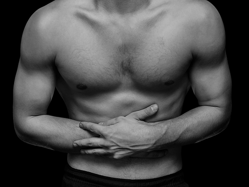 Young man compresses the abdomen due to pain, black and white image