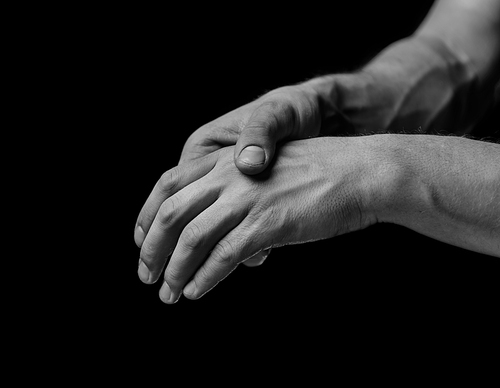 Pain in a male hand. Man holds his hand, black and white image