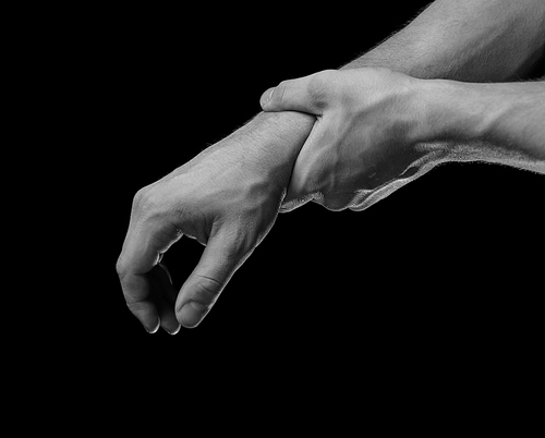 Man holds his hand, acute pain in a wrist, black and white image