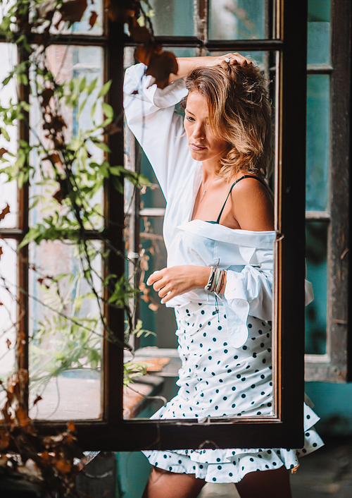 Beautiful woman model in an old house near window