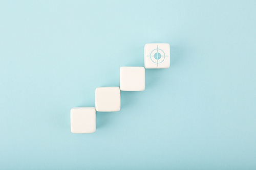 Ladder career, sales or business growth, success path or setting goal concept. White cubes as step stairs with target on bright blue background