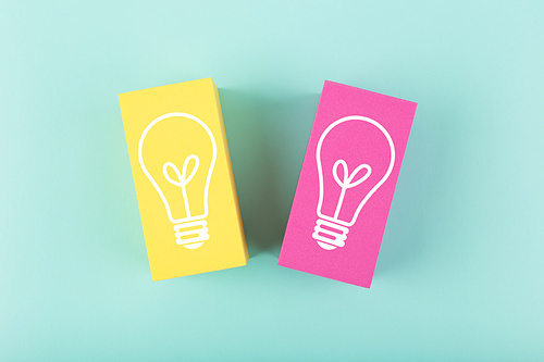 Concept of idea, creativity, start up or brainstorming. White drawn light bulbs on yellow and pink rectangles against bright blue background