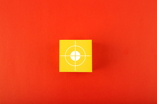 Goal symbol on yellow cube in the middle of red background. Concept of goal, success, reaching business and personal aims