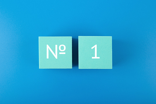 Number 1 written on light blue cubes against dark blue background. Concept of being first, best selling or award winner