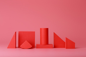Red geometric figures against dark pink background with copy space. Concept of minimalistic monochromatic backgrounds