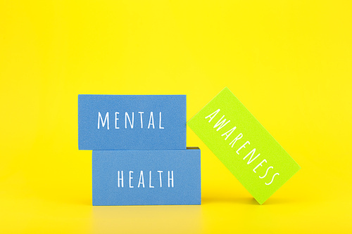 Mental health awareness concept on yellow background with text written on colorful rectangles. Concept of mental health, self care and psychological issues