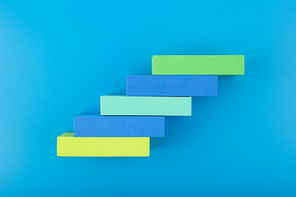 Ladder of success modern and trendy business or personal development concept. Top view of ladder made of multicolored rectangles with space for text against blue background
