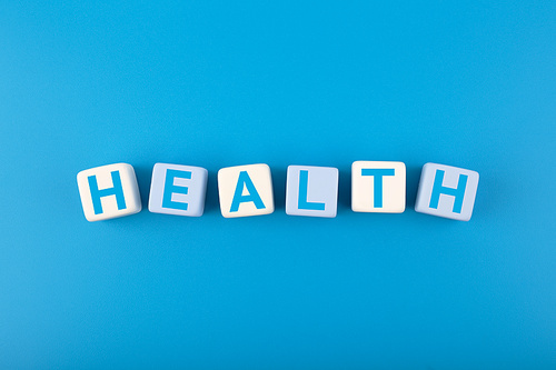 Health single word written on white and blue cubes in a row on dark blue background. Concept of mental and physical health, medications, life insurance or wellbeing