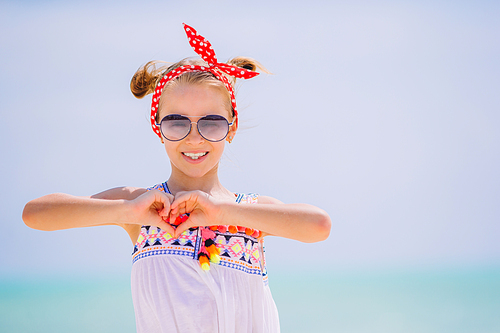 Beautiful little girl at beach having fun. Portrait of funny girl enjoy summer vacation