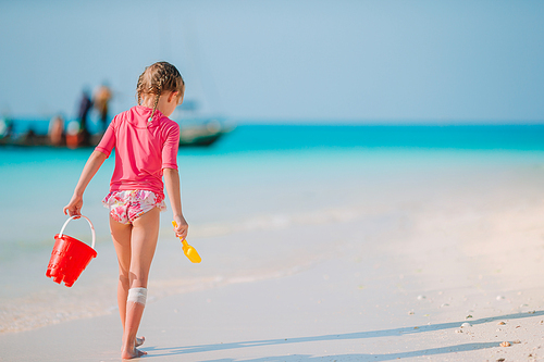 Kid fun. Little girl on the beach walking and playing