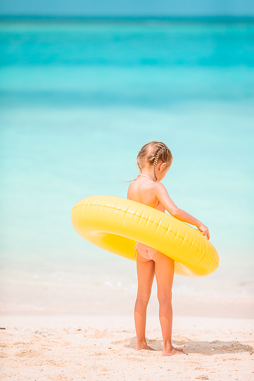 Happy child with inflatable rubber circle having fun on the beach