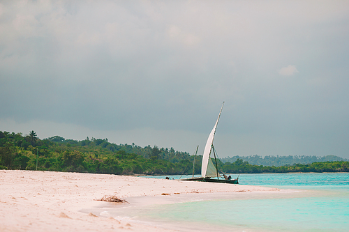 Beautiful white sandy beach with boats and clear turquoise water