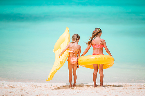 Little girls having fun at tropical beach playing together. Adorable little sisters at beach during summer vacation