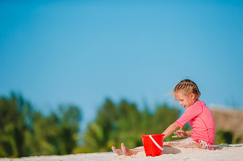 Adorable little girl playing with toys on beach vacation