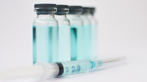 Medical ampoules and insulin syringe isolated on white, vaccination concept.