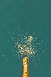 Bottle of champagne and confetti on green background, top view. Flat lay composition for entrepreneurs, bloggers, magazines, websites, social media and instagram