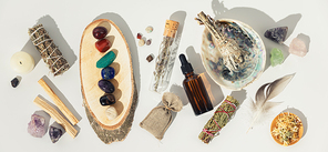 Healing crystals, elixir, palo santo, white sage bundle on abalone sea shell, dry healing herbs on white background. Relaxation and meditation kit. Witchcraft Ritual, Relaxing Chakra. Esoteric, wiccan, modern magic, life balance concept