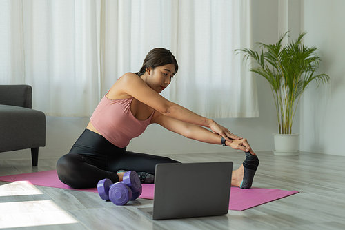 Young woman is exercising yoga at home. Fitness, workout, healthy living and diet concept.