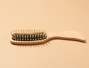 wooden hair comb on brown background, zero waste. Top view