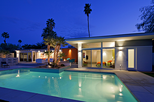 Illuminated swimming pool and villa at night