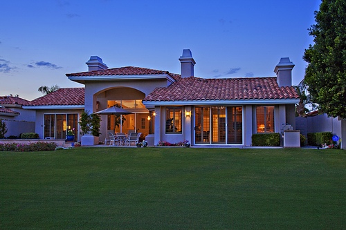 Facade of luxurious villa with lawn in foreground