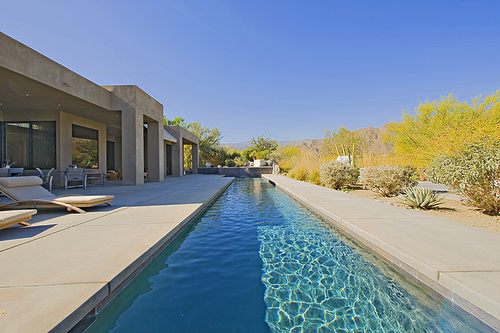 Patio of manor house with small pool and chaise lounges