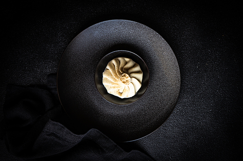 Traditional georgian dampling known as khinkali in georgian on black plate, served with black napkin on black concrete background  with copy space