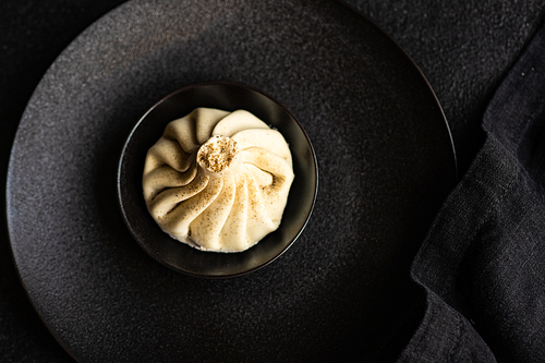 Traditional georgian dampling known as khinkali in georgian on black plate, served with black napkin on black concrete background  with copy space