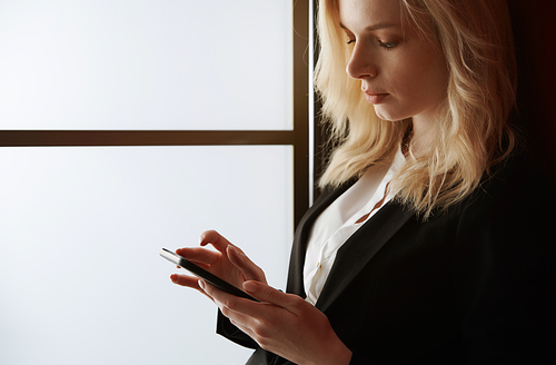 Young adult woman using smartphone at the office