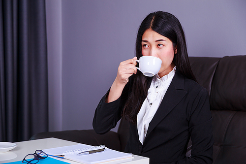 young business woman working and drinking a cup of coffee