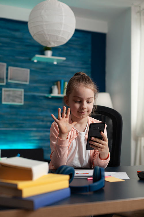 Little student girl using video call on smartphone to join online class conference for educational lesson on internet connection. Small child with modern technology for digital conversation