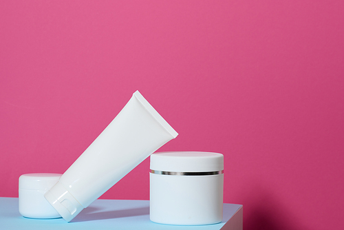 jar and empty white plastic tubes for cosmetics on a pink background. Packaging for cream, gel, serum, advertising and product promotion, mock up